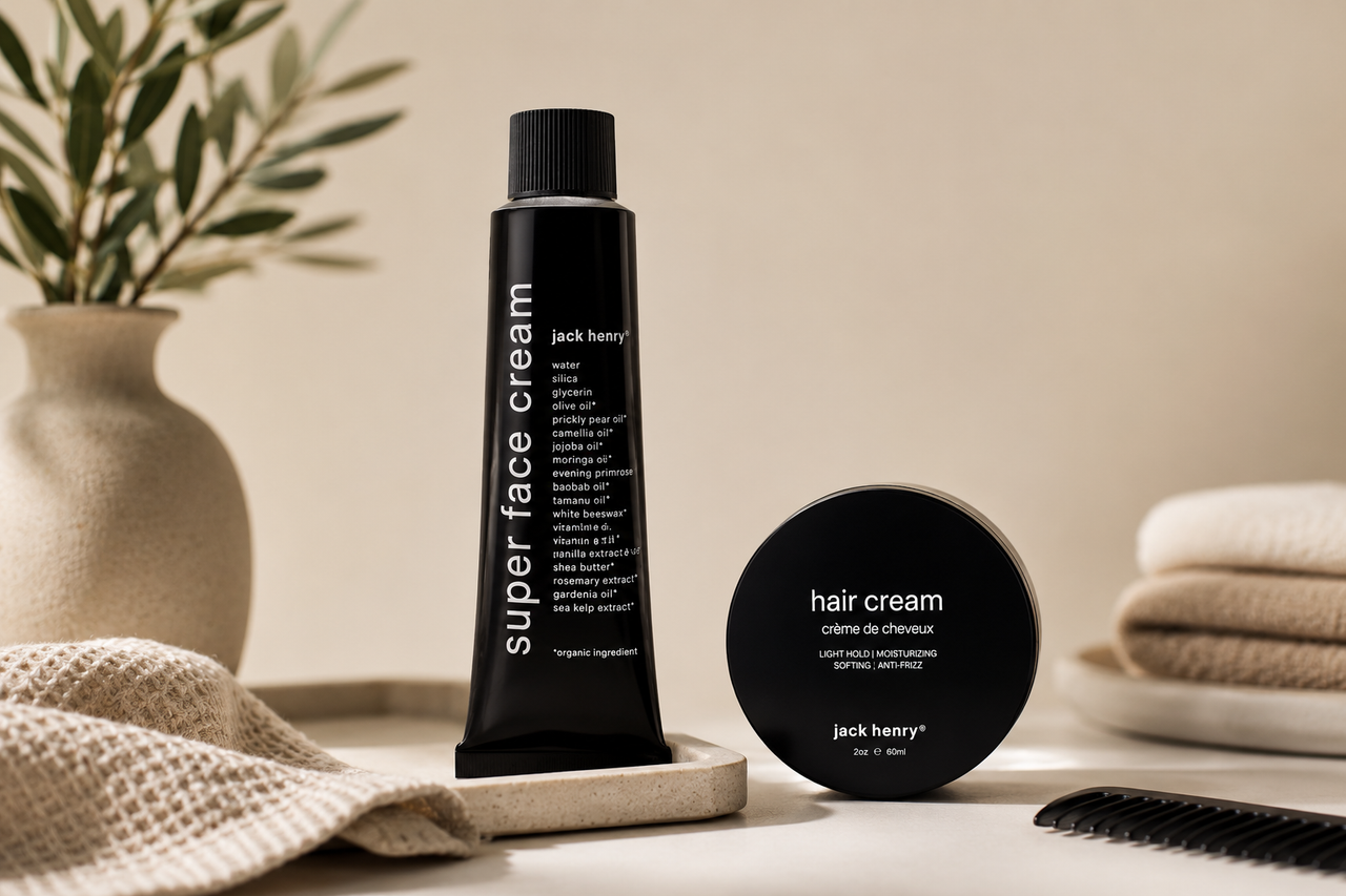 Jack Henry Super Face Cream and Hair Cream displayed in a modern grooming setup with neutral-toned towels, a styling comb, and natural décor, showcasing a premium men's skincare and haircare routine.